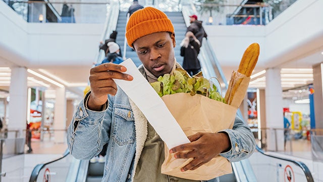 Grocery store customer looking at receipt