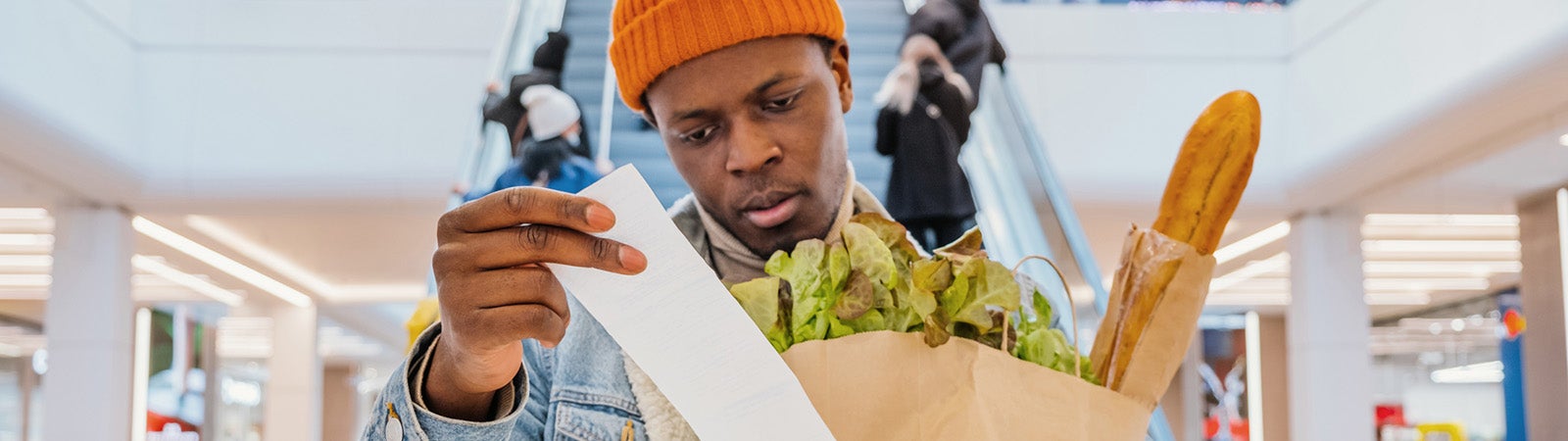 Grocery store customer looking at receipt
